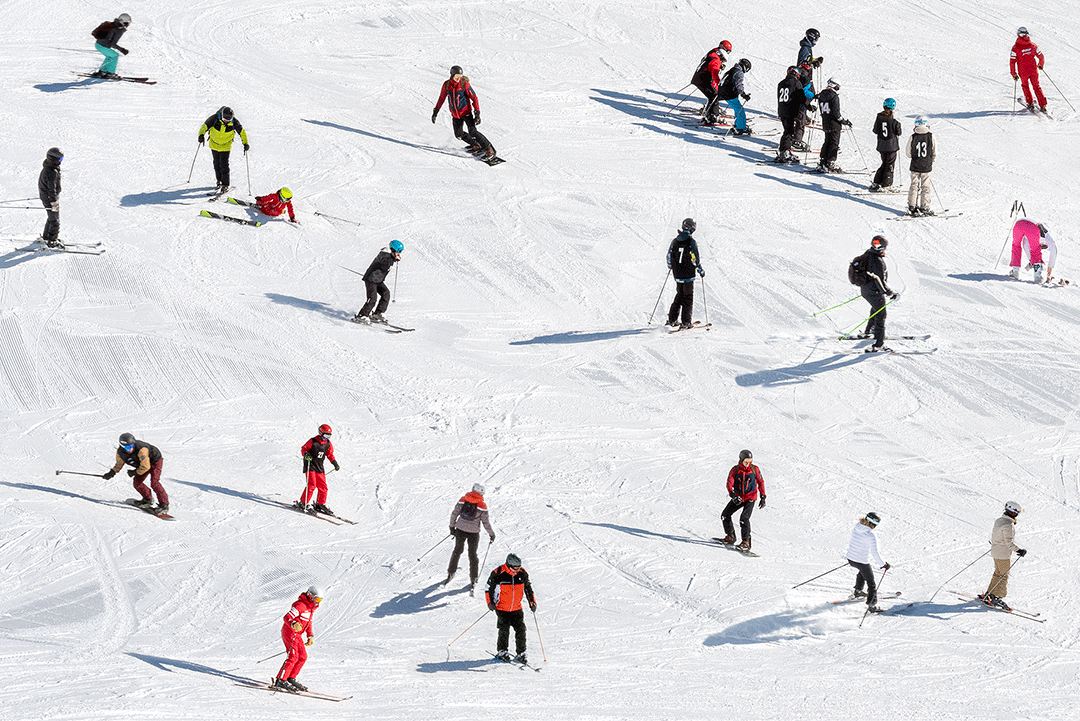 Des skieurs et skieuses sur une piste de ski.