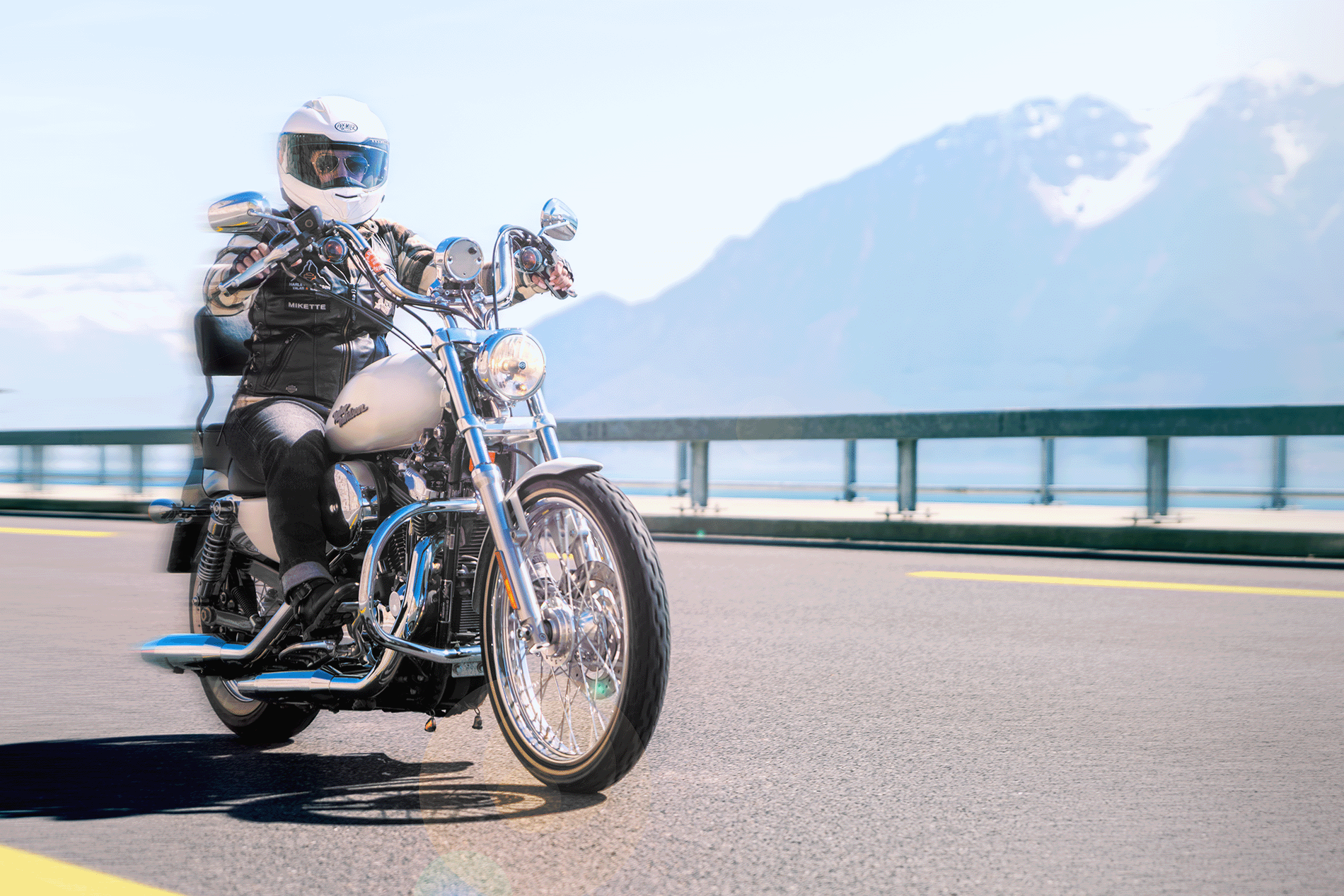 Une grosse moto sur la route de Lavaux, avec la glissière de sécurité. Au guidon, une personne casquée.