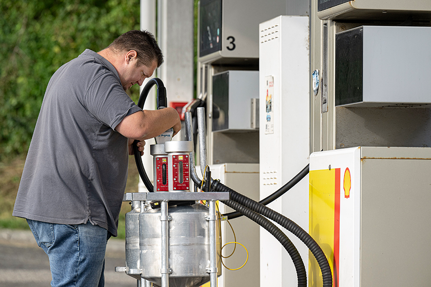 L'expert des poids et mesures en pleine inspection d'une pompe à carburant.