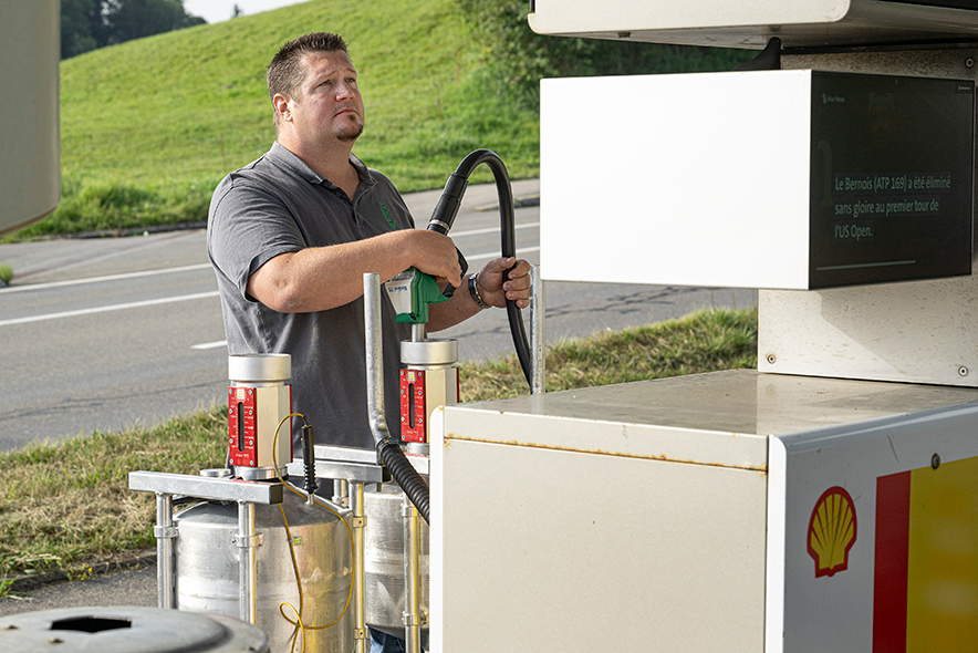 L'expert des poids et mesures en plein contrôle d'une pompe à carburant. Observant le débit affiché sur la pompe.