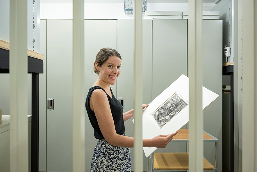 Anne Deltour montre une gravure dans les réserves du musée