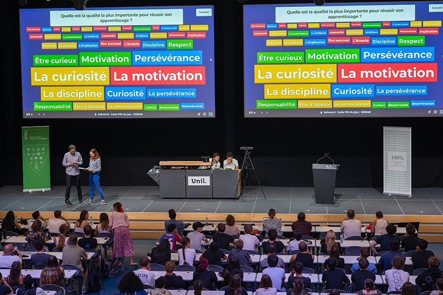 Une photo de la scène. Sur de grands écrans on lit les qualités les plus importantes pour réussir son apprentissage selon les personens présentes dans la salle