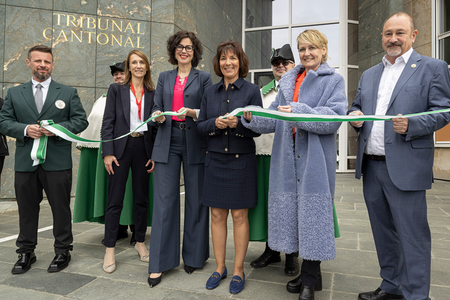 Les personnes en compagnies d'huissiers, au moment de couper le ruban symbolique