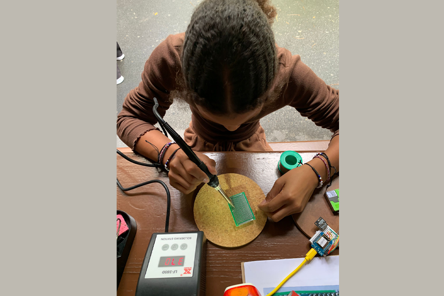 Une jeune fille manipule un électromètre sur un circuit électrique
