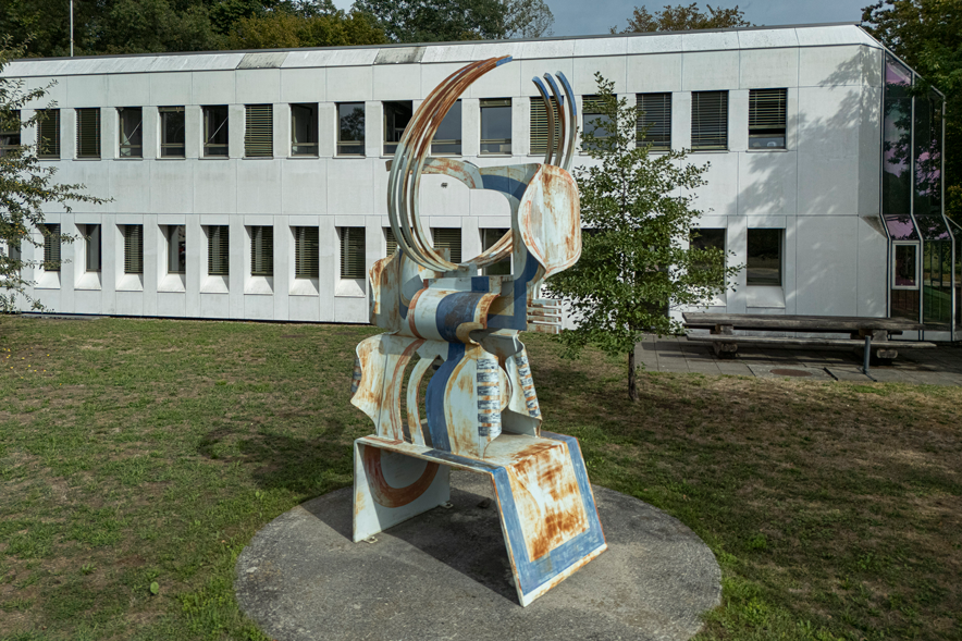 Sculpture métallique d'une certaine taille, blanche et bleue, rouillée. Elle fait penser à un ruminant à corne, car deux séries de barres recourbées sont dressées vers le ciel, comme des cornes. La partie centrale, cylindrique, pourrait être le corps.