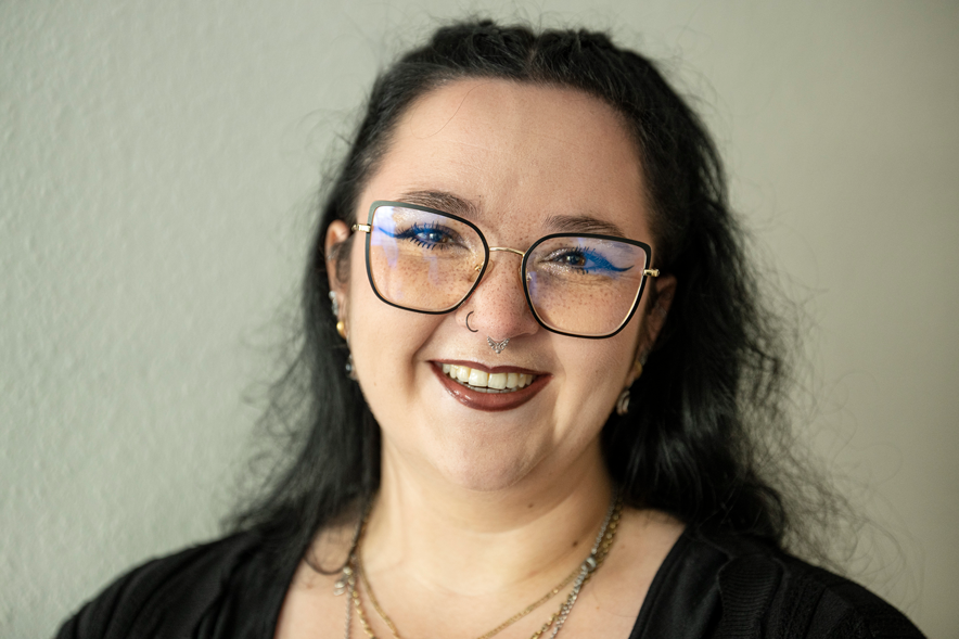 Portrait de Lorianne Goy. Elle porte des lunettes et un petit piercing dans le nez.